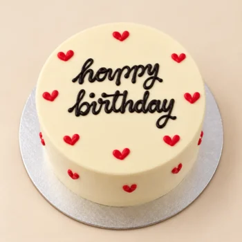 Happy Birthday Bento Cake with ivory frosting, black lettering, and red heart decorations