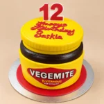 Custom Vegemite jar-shaped birthday cake with yellow frosting and personalised decorations by SJ Cake Art